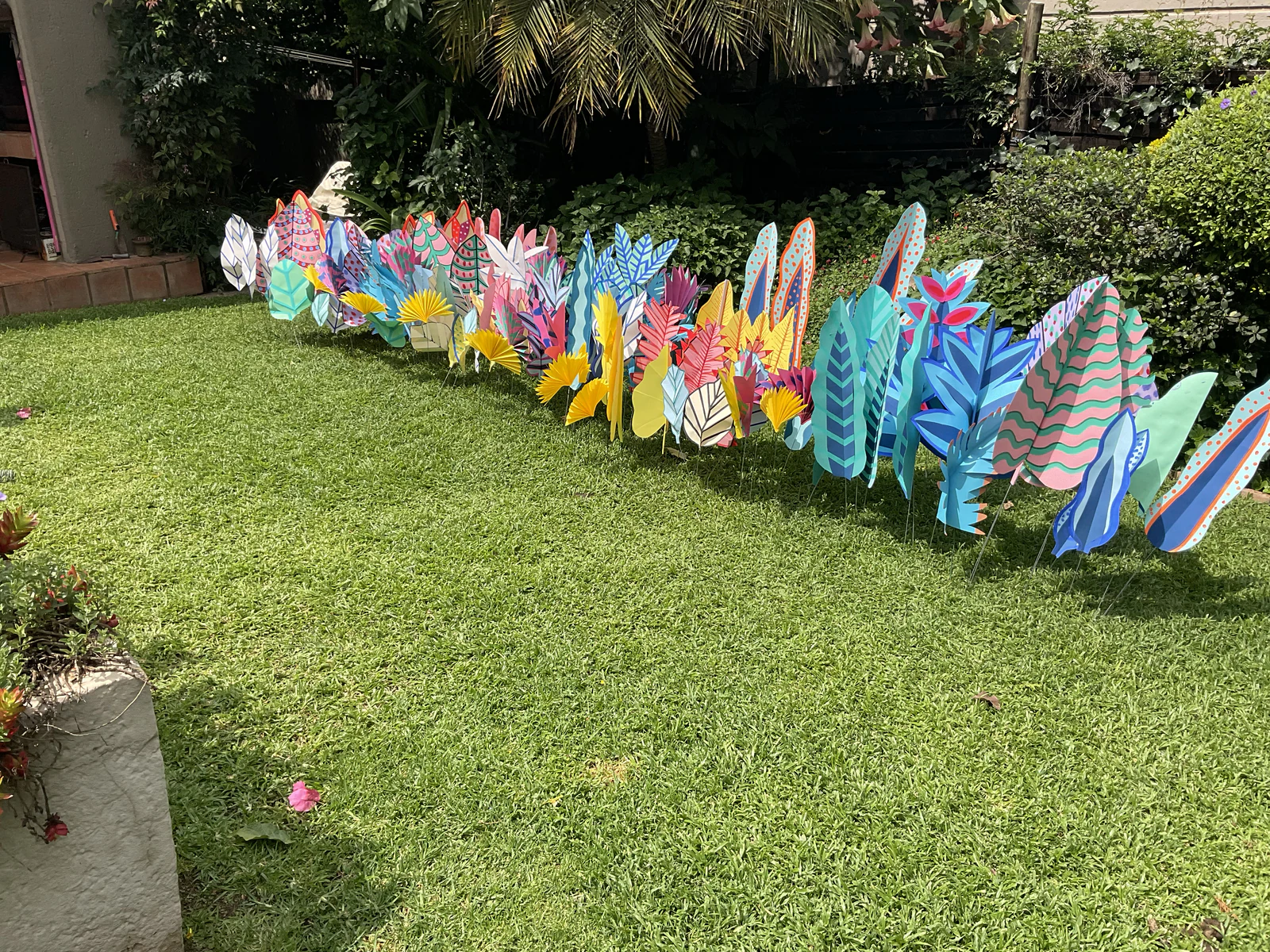 A long border of hand-painted paper leaves curving along a lawn