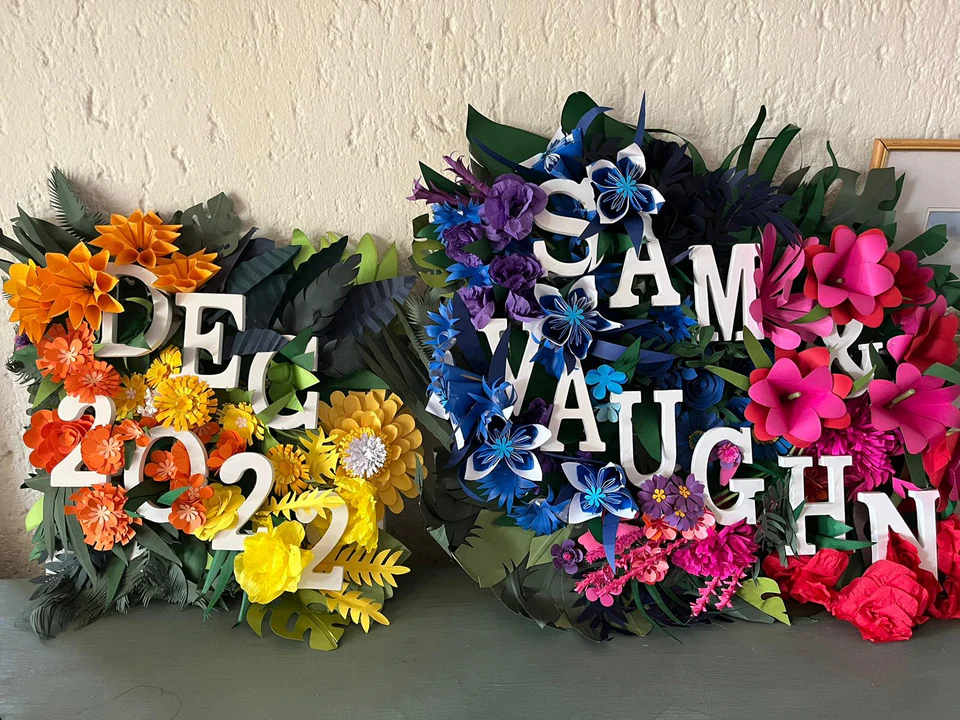 Two paper flower panels side by side, one reading Dec 2022 and one reading Sam and Vaughn