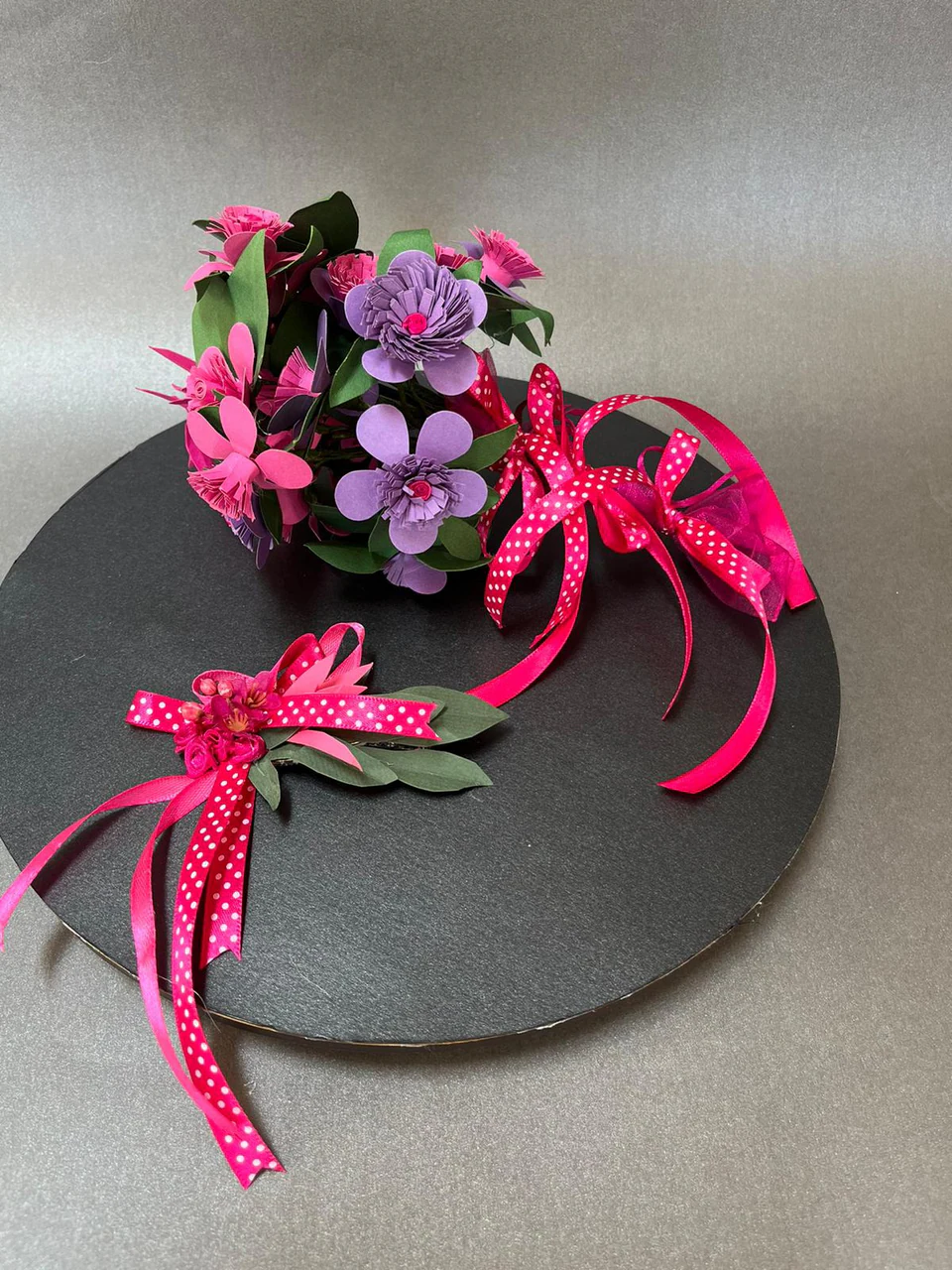Paper blossoms in pinks and purples with a spotted ribbon