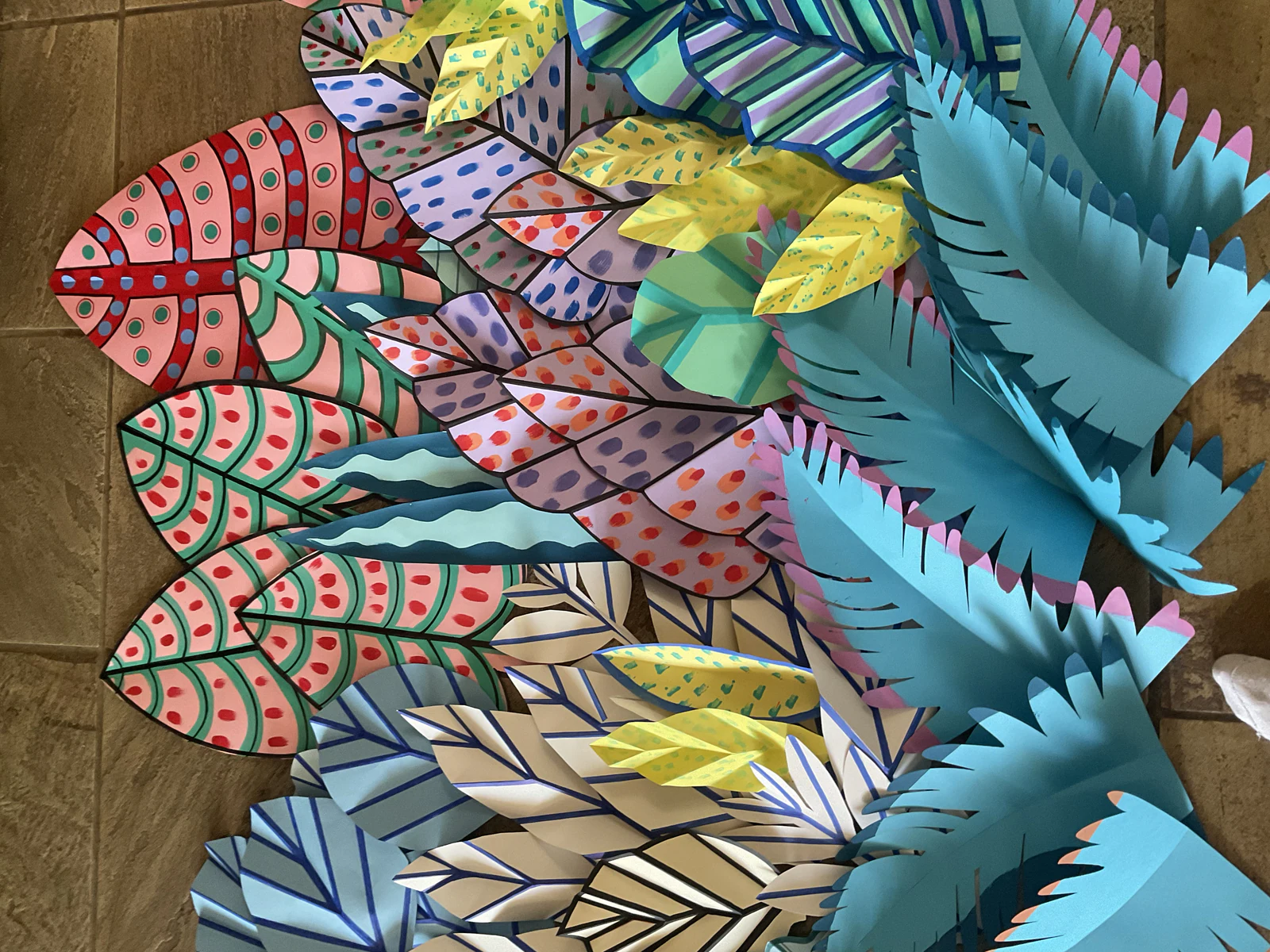 Close view of painted paper leaves in red, lilac and blue